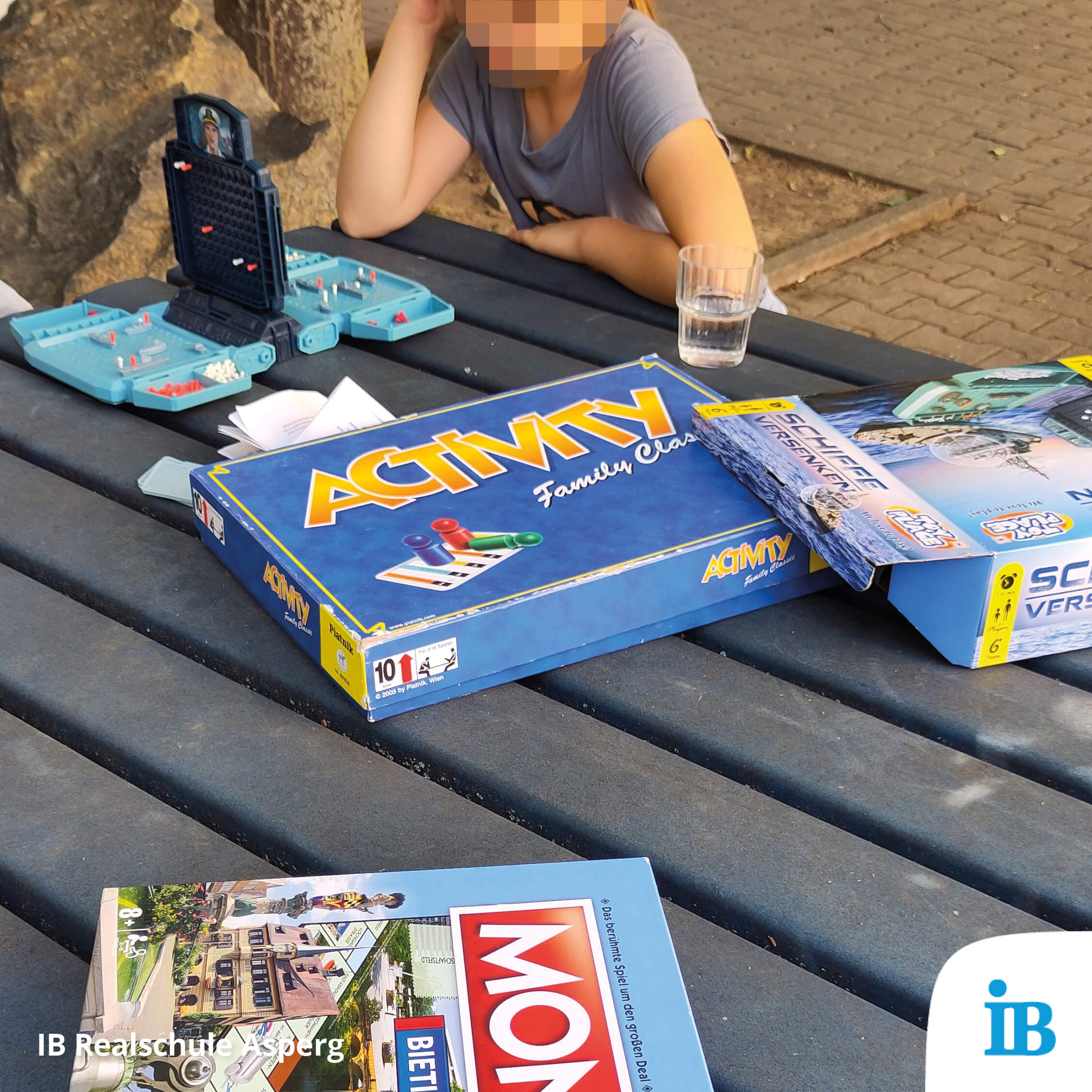 Ein Kind spielt Brettspiele, darunter Activity, auf einem Tisch während eines geselligen Patennachmittags an der Realschule.